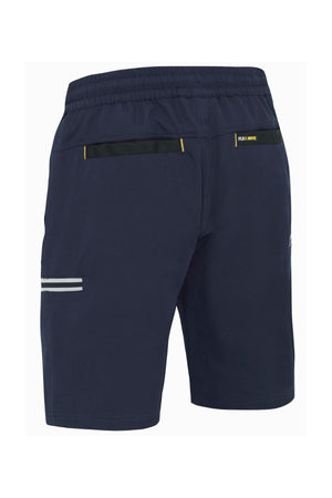 The Bisley Flex & Move 4 Way Stretch Elastic Waist Cargo Short is seen from the rear in a dark blue color. These shorts are made with a 4-way stretch fabric and feature an elastic waistband and two black back pockets. A small logo is present on the right side, along with a white reflective stripe on one side, enhancing their lightweight design ideal for sports activities.