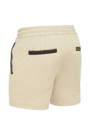 The Bisley Flex & Move 4 Way Stretch Elastic Waist Short in beige is crafted for comfort, featuring a 4-way stretch design. It includes an elastic waistband and side pockets with Cordura® black zipper details. Two back pockets trimmed in black and a small black label with yellow text enhance its stylish functionality.