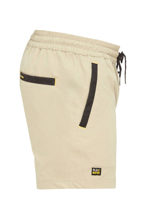 Side view of the Bisley Flex & Move 4 Way Stretch Elastic Waist Short in beige, showcasing black accented pockets and an elastic waistband with a drawstring. Made with Cordura® fabric for durability, these shorts feature a small "Flx Move" logo patch near the bottom hem.