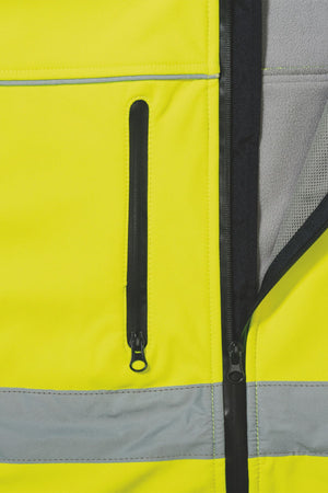 Close-up of the Bisley Hi Vis Soft Shell Taped Jacket in high-visibility yellow, showcasing its reflective taping and black zipper. The water-resistant jacket is partially unzipped, revealing a comfortable gray inner lining.