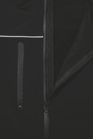 Close-up of the Bisley Soft Shell Jacket, showcasing its showerproof black design. The partially open front zipper and additional vertical zippered pocket on the left side are highlighted, along with a thin white stripe running horizontally above the pocket. Reflective piping enhances visibility.