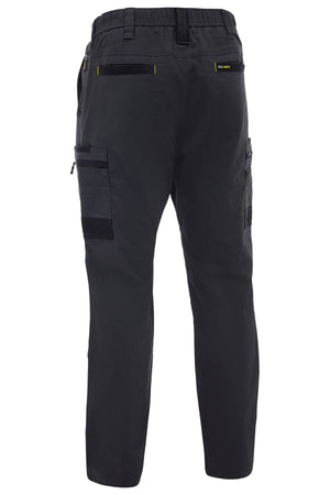 Rear view of the Bisley Flex & Move Stretch Canvas Elastic Waist Cargo Pant, featuring multiple leg and back pockets (zippered and flap), elastic waistband, and yellow accent stitching in stretch cotton canvas.