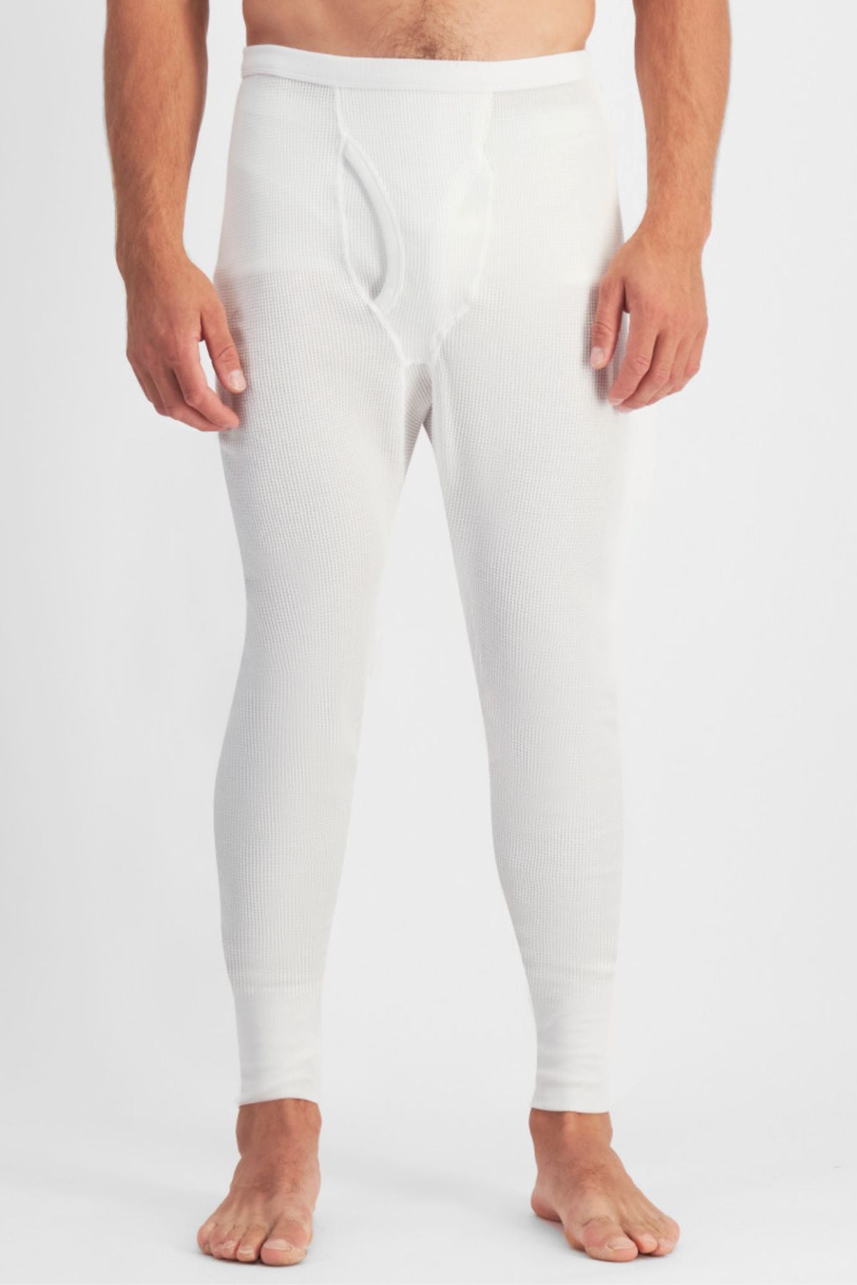 A man stands barefoot, wearing Bonds Aircel Thermal Long Johns with a ribbed elastic waistband and fly front, shown from chest down against a plain light background.