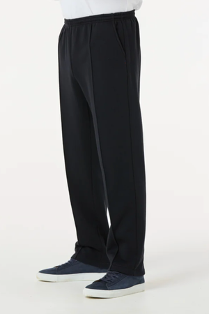 A person is shown from the waist down wearing Breakaway Classic Snowy Mt Fleece Pant in black with navy blue sneakers, standing against a plain white background.