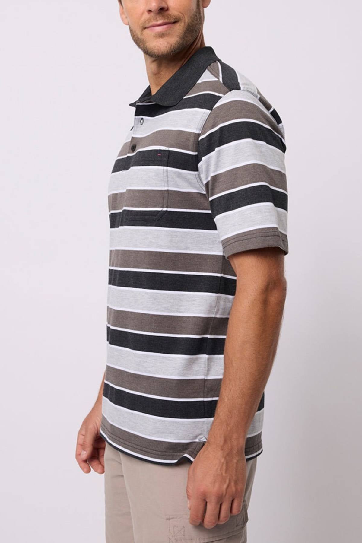 A man wears the Breakaway Coleman Kinnersly Polo, a grey, black, and white striped men's polo in a comfy cotton-polyester blend, with light khaki shorts against a plain light background.