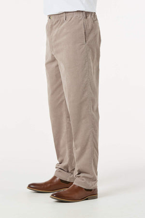 A person is shown from the waist down, wearing Breakaway Cordeaux Pant in light brown with an elasticised waist and brown leather shoes, standing against a white background.