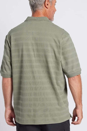 A man with grey hair is facing away from the camera, wearing a light green, short-sleeve Breakaway Emil Polo. The shirt is crafted from 100% cotton and features a self-jacquard stripe texture, adding subtle detail to his attire. He stands against a plain white background.