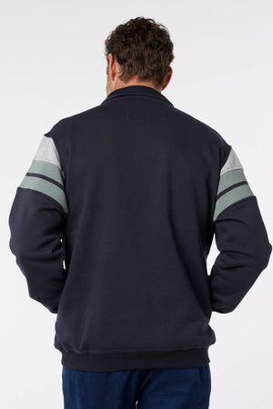 A man with short, curly brown hair is seen from behind wearing the Breakaway Henrich Snowy Mt Fleece Half Zip in dark navy, featuring light gray and green sleeve stripes. His arms hang relaxed by his sides against a plain white background.