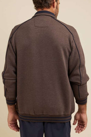 A man wearing a Breakaway Kyler Snowy Mt Fleece Jacket with navy blue trim stands against a soft beige backdrop, his hands relaxed by his sides, highlighting the jacket's stylish design.