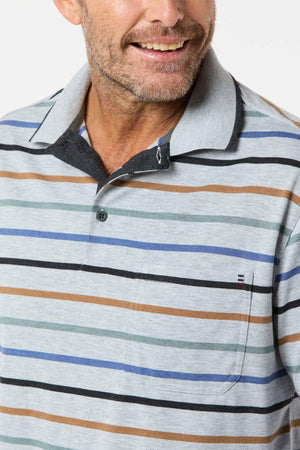 A man wearing the Breakaway Lendel Kinnersly Polo with blue, green, black, and brown stripes smiles while looking to the side. This polo features a chest pocket, rib knit cuff sleeves, and a buttoned neckline.