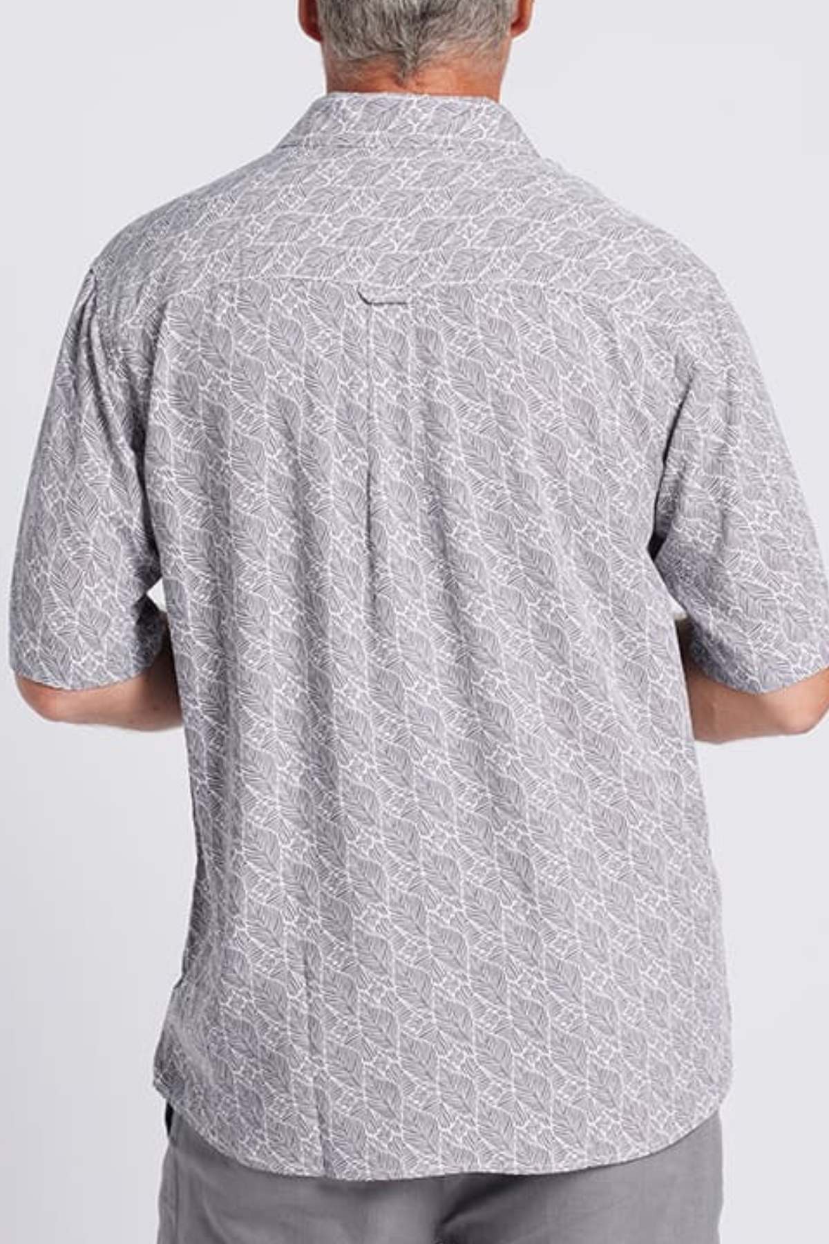 A man with short gray hair is seen from the back wearing the Breakaway Shaw Bamboo Shirt, which features a refined leaf print and smart pocket, paired with gray pants against a plain light background.