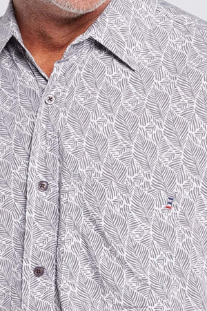 Close-up of a man in the Breakaway Shaw Bamboo Shirt, showcasing a refined leaf print, front buttons, chest pocket, and subtle embroidered logo. Only his neck and part of his face are shown.