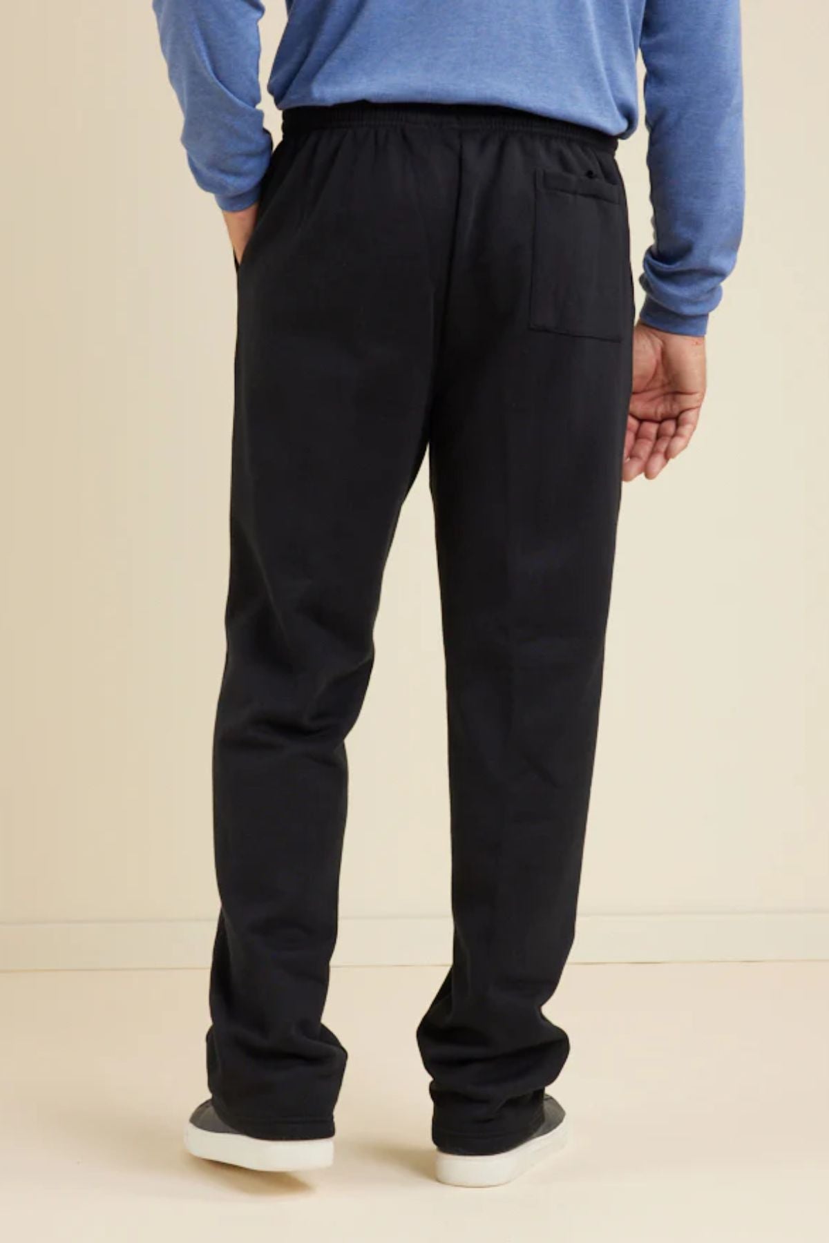 A person stands facing away from the camera in a blue long-sleeve shirt and Breakaway Pocket Snowy Mt Fleece Pant with an elasticated waist, their right hand relaxed by their side against a neutral background.