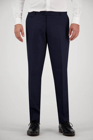 A person wearing a white shirt and dark blue Bruton Jesse Trousers stands against a plain background. Only the lower torso and legs are visible, complemented by black dress shoes.