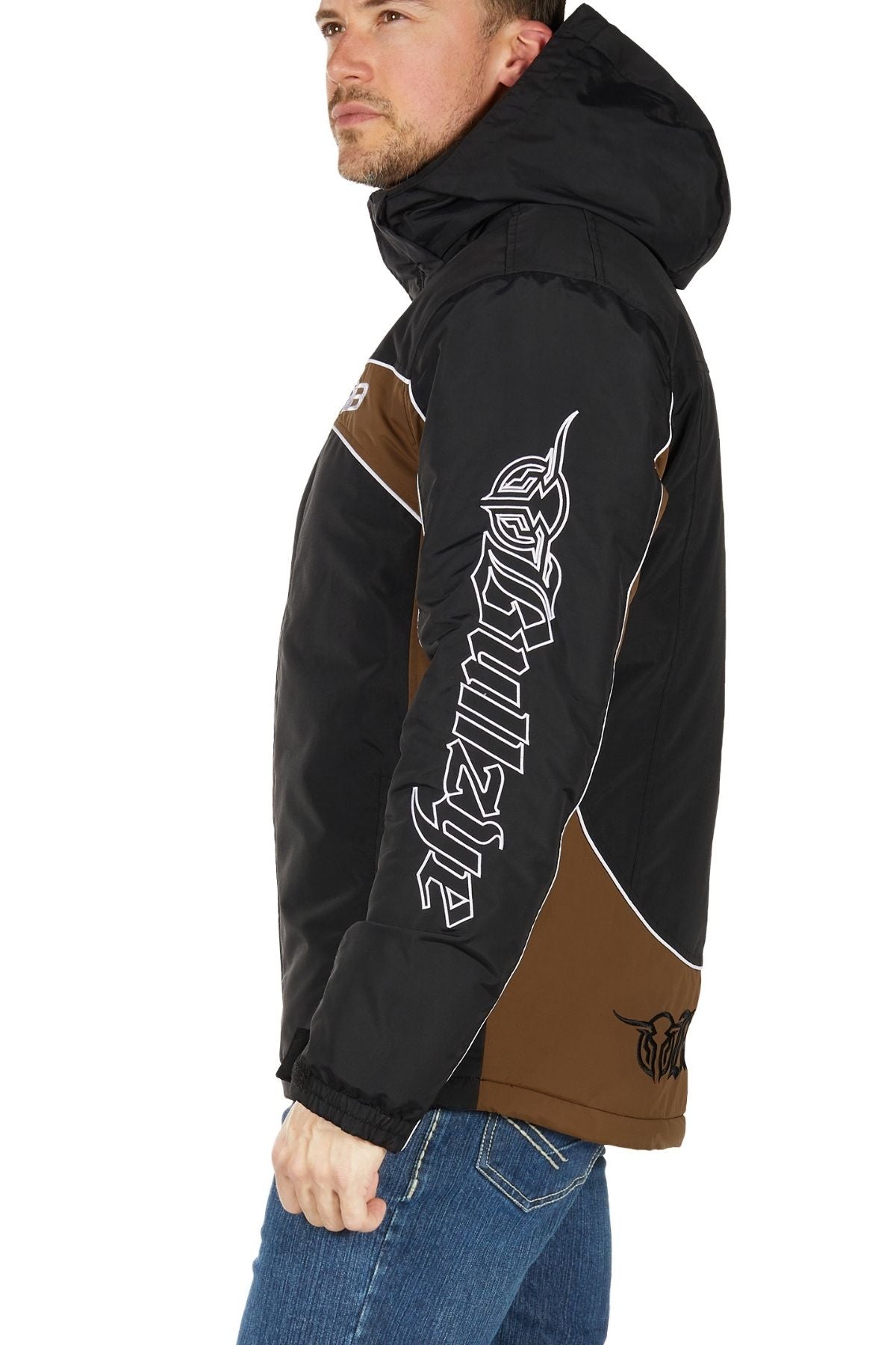 A man in profile wears the Bullzye Bazooka Jacket—rugged black and brown, waterproof, with white graphic text on the sleeve—against a plain white background.