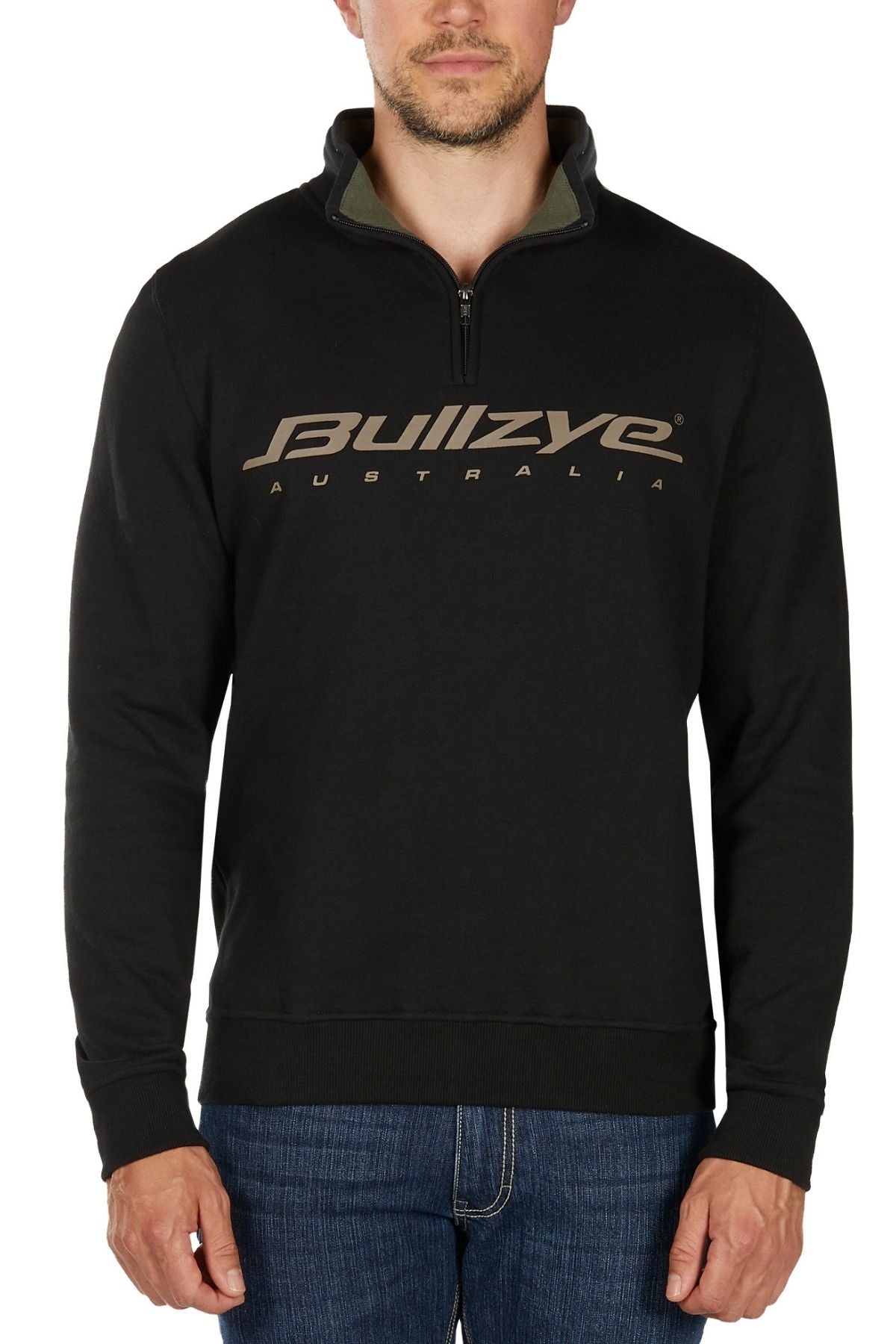 A man wearing a black Bullzye Logo 1/4 Zip Pullover and blue jeans stands against a white background.