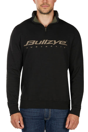 A man wearing a black Bullzye Logo 1/4 Zip Pullover and blue jeans stands against a white background.