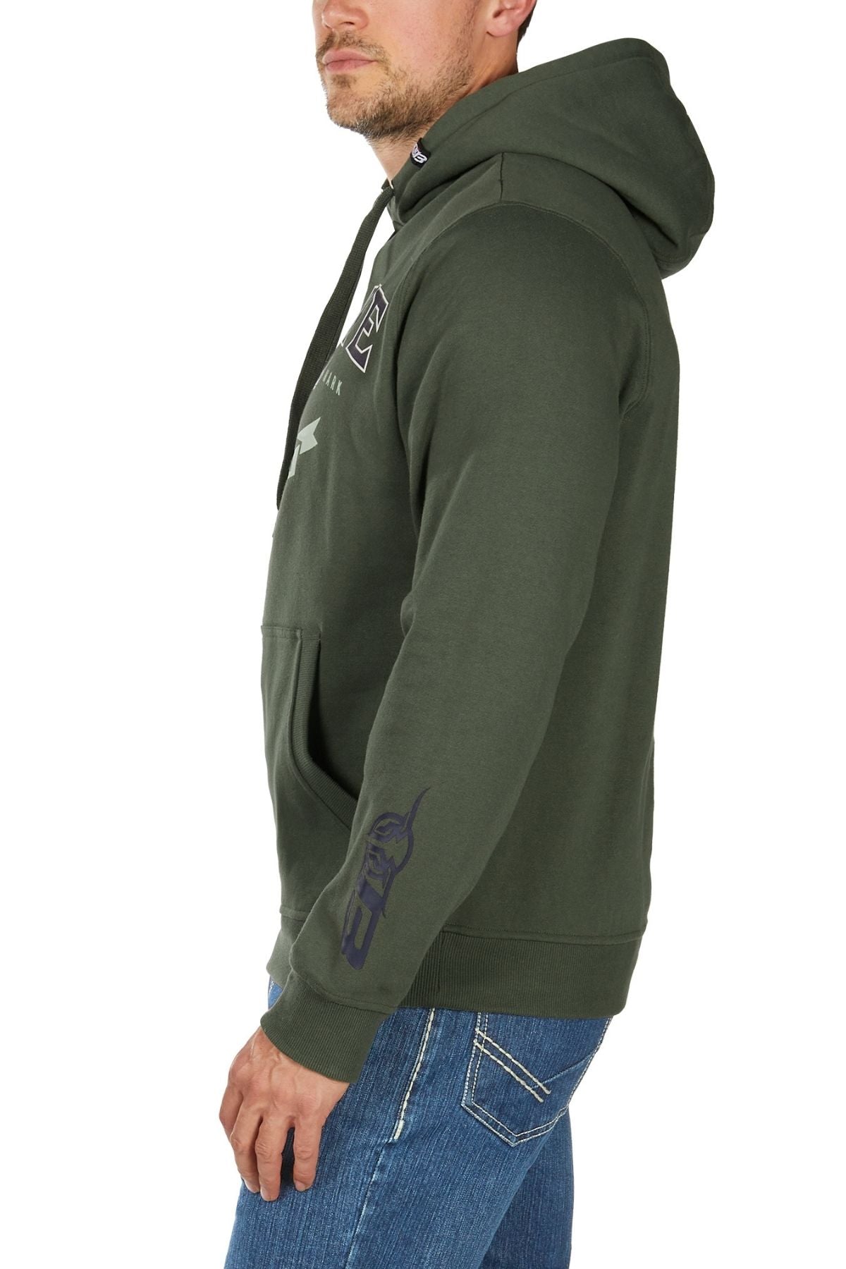 A man stands sideways wearing the Bullzye Original Hoodie in olive green, featuring white chest graphics and a bull graphic on the sleeve, paired with blue jeans. His left hand rests relaxed by his side.