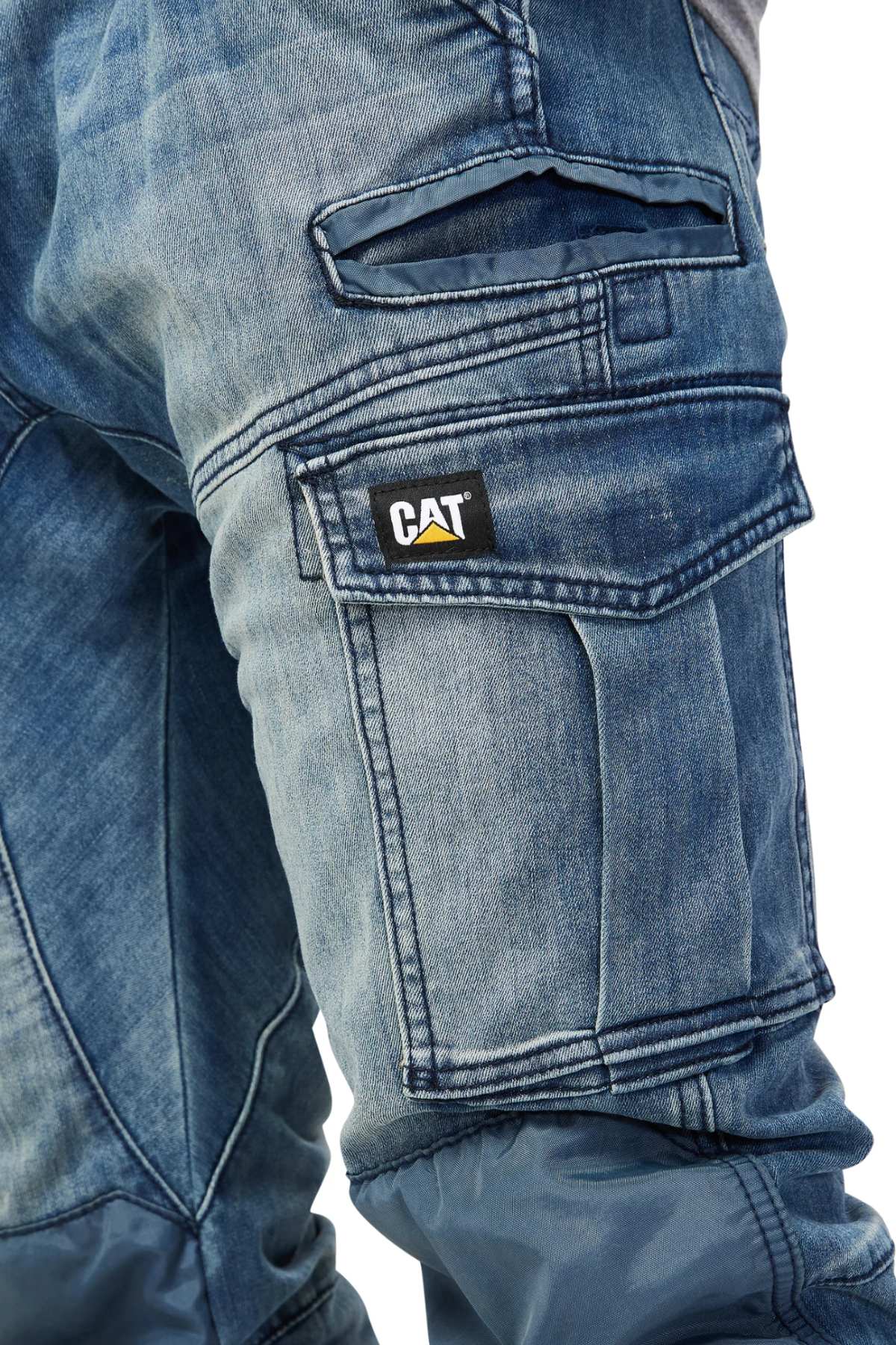 Close-up of CAT Dynamic Denim Pant in blue denim, featuring multiple pockets—including cargo and flap pockets with a visible CAT logo patch—and reinforced knee patches for extra durability.