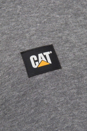 A close-up image of the gray fabric on the CAT Essential 1/4 Zip Sweatshirt shows a black rectangular patch sewn on. The patch features the word "CAT" in bold white letters with a yellow triangle under the letter "A." The sweatshirt boasts super soft fleece lining and nylon overlays at the shoulders.