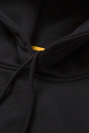 Close-up of the neckline and adjustable hood of the black CAT Essential Hooded Sweatshirt, highlighting the drawstrings and offering a peek of the yellow inner fabric lining. The soft, slightly textured fabric suggests comfort while exuding a stylish charm.