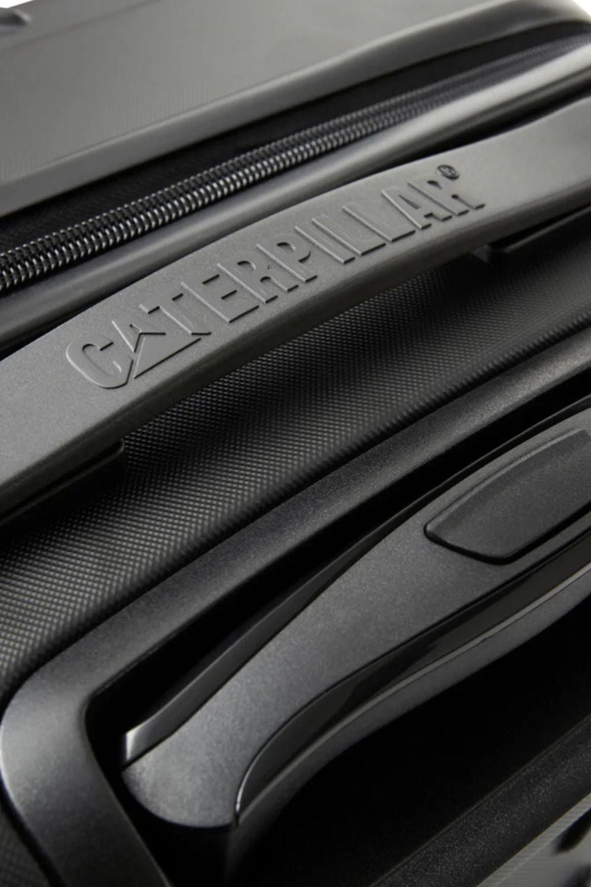 Close-up of the textured handle on the CAT Industrial Plate 24" Trolley, featuring the embossed Caterpillar logo and part of a zipper—ideal extra-capacity luggage with a secure TSA lock.