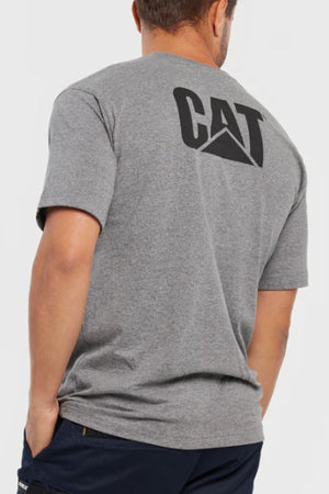 A man seen from behind wears the CAT Trademark Tee, a gray crew neck with a large black "CAT" logo on the back, and has one hand in his dark pants pocket.