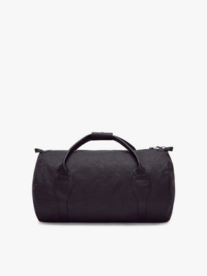 The RM Williams Canvas Ute Bag is a black duffel with water-resistant fabric, dual handles, and a shoulder strap, shown against a plain white background.