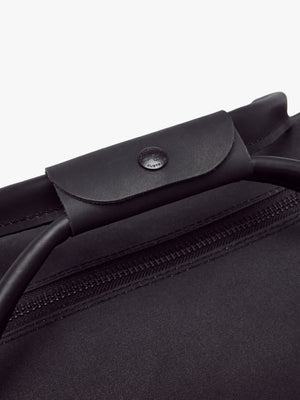 Close-up of the RM Williams Canvas Ute Bag’s water-resistant, minimalist design with sturdy leather handles featuring button detail over a fabric zipper. The durable canvas makes this sleek bag stand out in style.