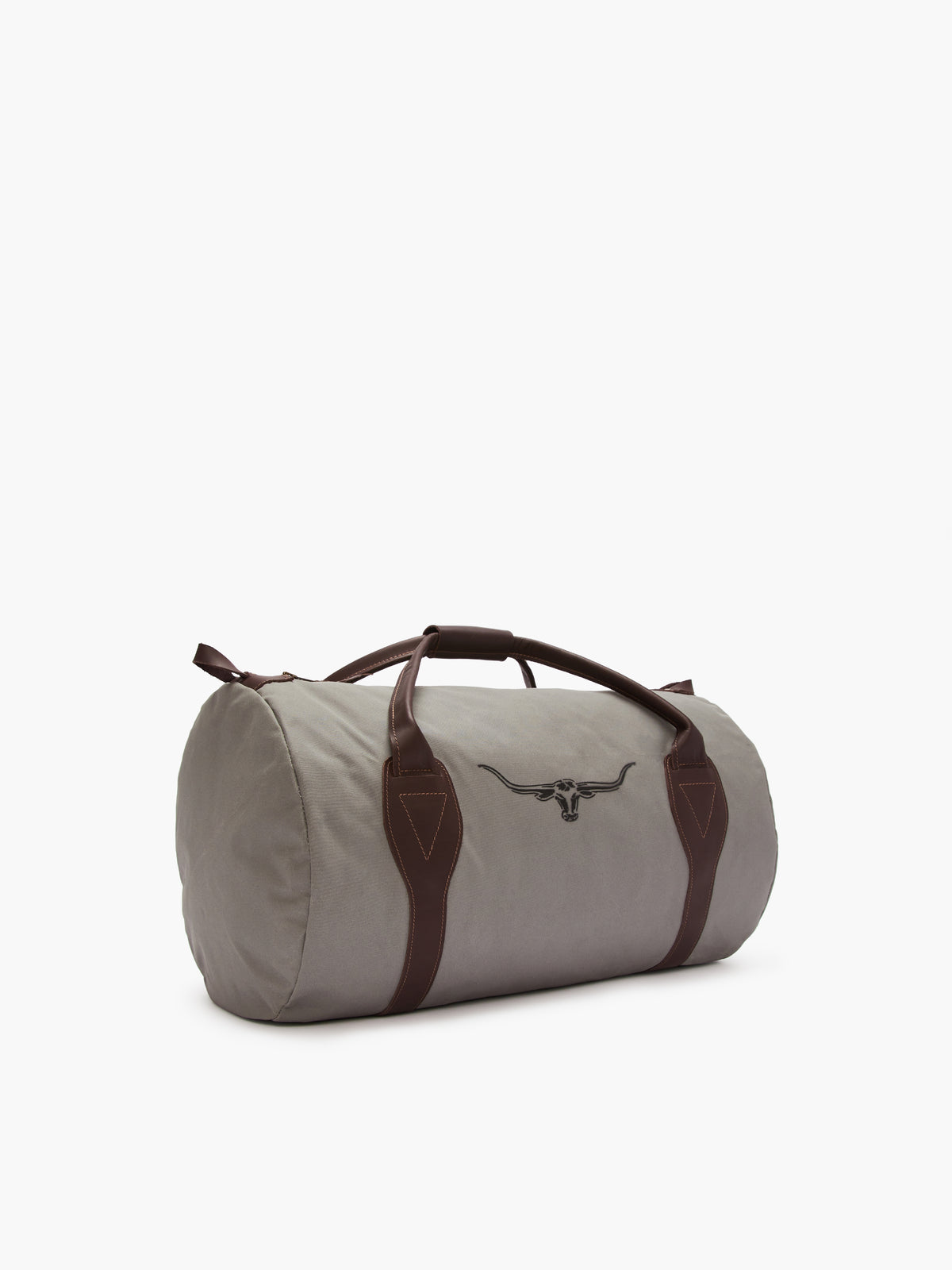 The RM Williams Canvas Ute Bag is a grey cylindrical duffel made from water-resistant utility canvas, featuring brown leather handles, accents, and a bullhead logo. It's stylishly angled against a plain white background.