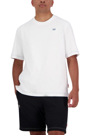 A person stands with one hand in their pocket, wearing an oversized fit Canterbury CCC Collection T-Shirt made from 100% cotton and black shorts, against a white background.