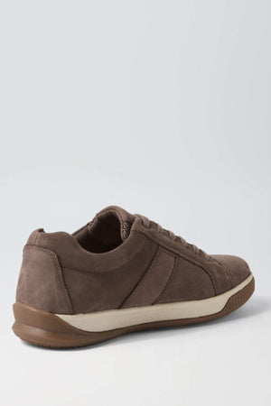 A single Colorado Edo Sneaker, featuring a brown suede-like material with stitching details, a white and brown sole, and laces, is shown from an angle highlighting both the side and back. The minimalist design of the casual shoe stands out against a plain, light-colored background.