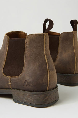 A close-up of two Colorado Lizard Oil Suede Boots, highlighting their brown oiled suede finish, pull tabs, elastic side panels, detailed stitching, rugged style, durable soles, and classic wooden heels.