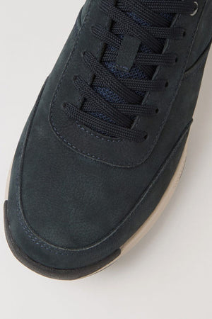 Close-up of the toe and laces of the Colorado Suzuki Shoe, a dark navy blue sneaker with black laces, a white slip-resistant sole, and premium leather, shown against a plain light background.