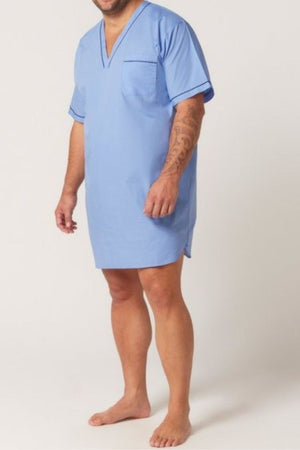 A man stands barefoot wearing the Contare Country Cotton Rich Short Sleeve Nightshirt in light blue, featuring a V-neck, chest pocket, and mid-thigh length. His face is partially out of frame.