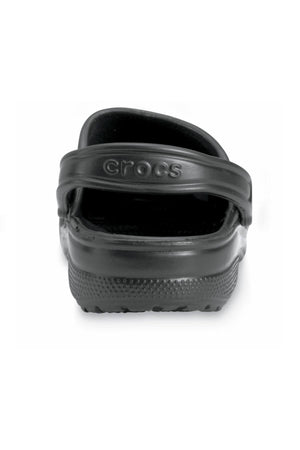 A close-up view of a single Crocs Classic Clog in black from the back, highlighting its textured sole and adjustable heel strap with "Crocs" embossed on it. Ideal for any water adventure, this lightweight footwear combines comfort and durability.