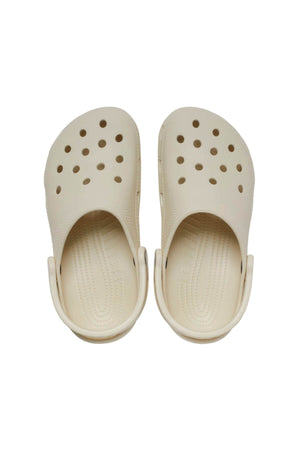 A pair of Crocs Classic Clog in beige rubber features large top ventilation holes and a textured insole. Lightweight and breathable, they have an adjustable back strap for a secure fit, viewed from above.