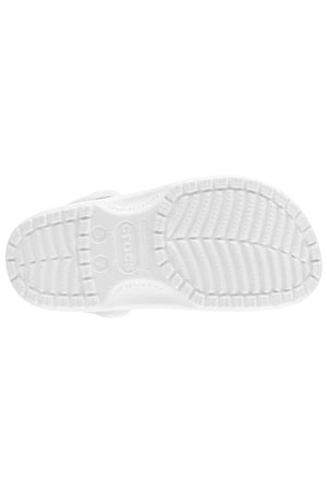 The Crocs Classic Clog in white features a prominently visible tread pattern adorned with "CROCS" text and circular shapes on the sole. This lightweight and breathable sandal is shown facing downwards, presenting a view of the bottom design, making it perfect for any water adventure.