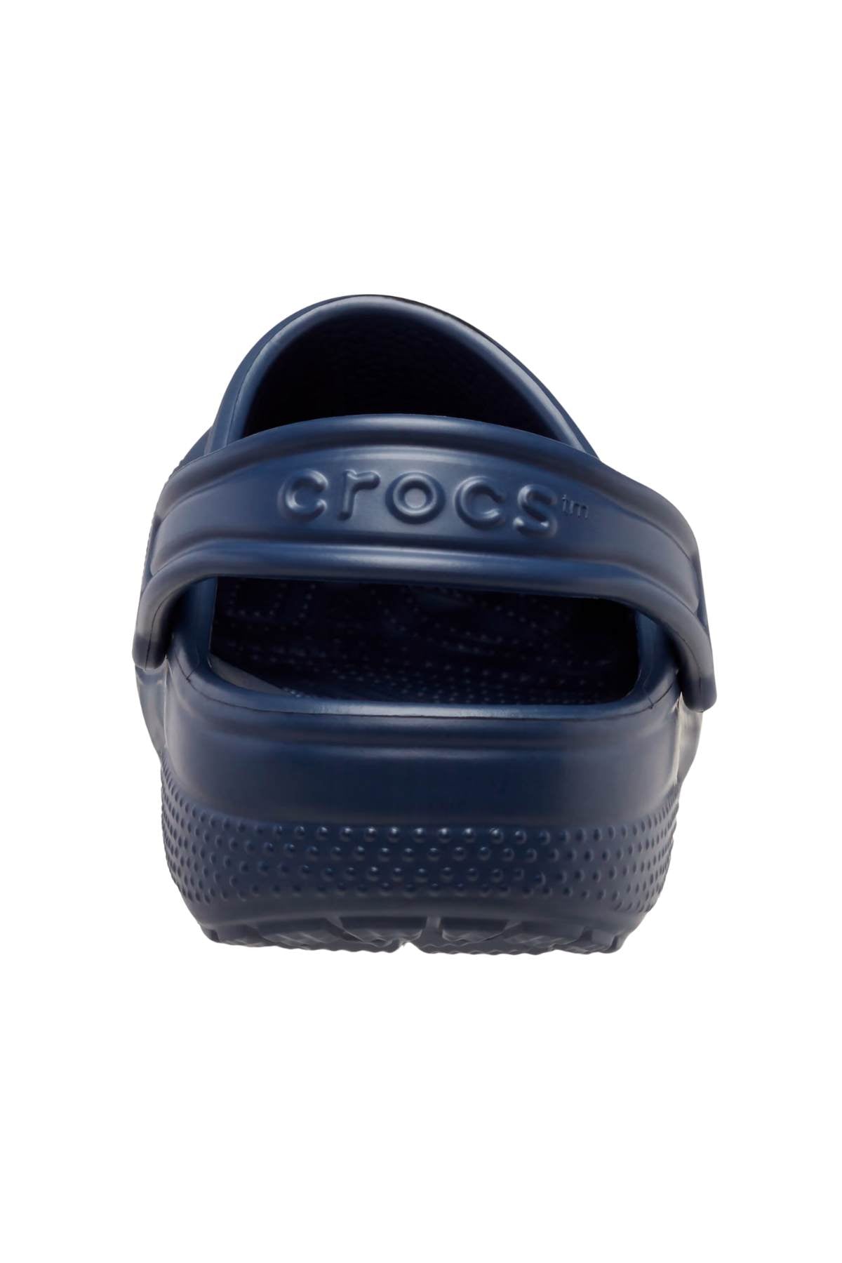 A single dark blue Crocs Classic Kids Clog seen from the back, showcasing a textured sole and a pivoting heel strap crafted from Croslite™ material. The "Crocs" brand name is embossed on the strap, representing iconic Crocs Comfort™.