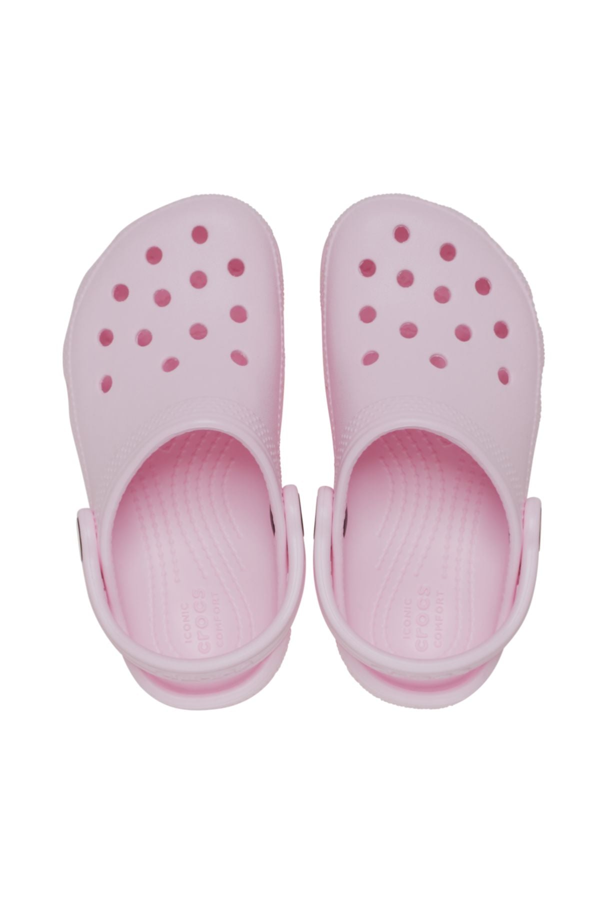 The Crocs Classic Kids Clog in light pink features ventilation holes and adjustable back straps, shown from above on a white background—ideal, comfortable everyday shoes for kids.