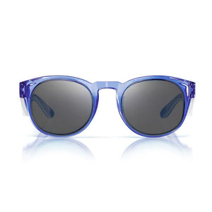 The SafeStyle Cruisers Blue Frame Tinted Lens sunglasses feature round, blue-transparent polycarbonate frames and dark tinted lenses, shown on a white background with a subtle reflection underneath.