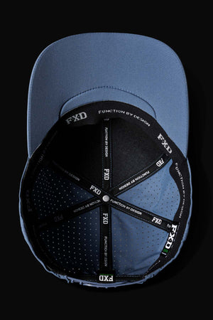The FXD CP-12 Tech Baseball Cap is shown upside down on a black background, revealing its interior. It features a black inner band with "FXD FUNCTION BY DESIGN" text along the seams, crafted from breathable, quick-drying polyester.