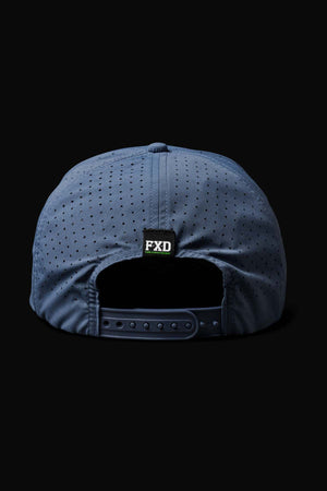 The FXD CP-12 Tech Baseball Cap in blue features a back view with perforations for breathability, made from quick-drying polyester. It includes an adjustable strap with snap closure and a small black label with "FXD" in green and white above the opening.