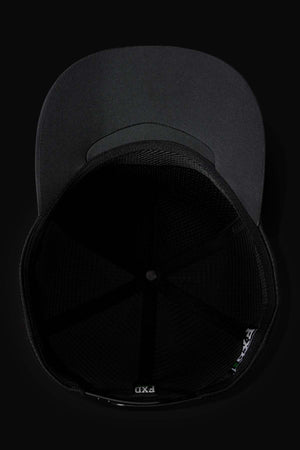The FXD CP-13 Trucker Cap in black is pictured from below, revealing its breathable mesh interior and an adjustable snap-back strap, with the brim visible at the top against a dark background.