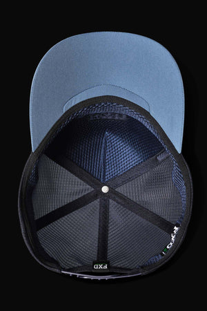 The image displays the underside of a blue FXD CP-13 Trucker Cap featuring a black mesh interior and visible segment-stitching. The cap includes a moisture-wicking sweatband and an inside label marked "PXD." Its brim is blue against a black background.