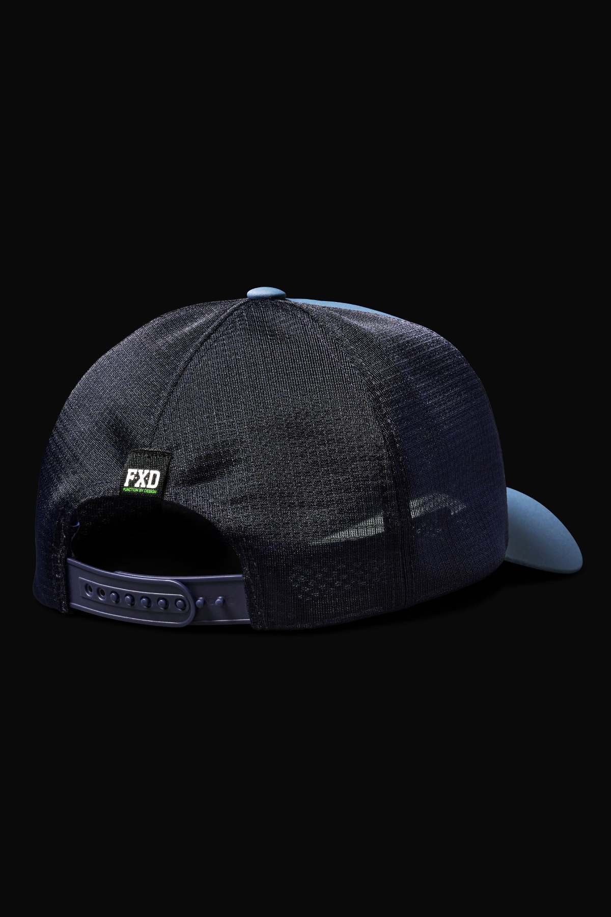 The FXD CP-13 Trucker Cap in dark color showcases a breathable design with an adjustable strap featuring holes. It includes a moisture-wicking sweatband and a small "FXD" label on a black background, viewed from the back.