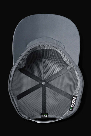 Top-down view of the FXD CP-13 Trucker Cap with grey mesh, solid brim, black internal bands, inside brand tags, breathable fabric, and an adjustable snap-back. The background is solid black.