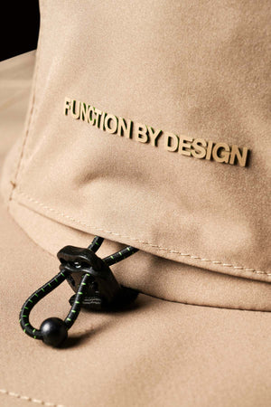 Close-up of the FXD CP-14 Boonie Hat featuring a beige fabric with "FUNCTION BY DESIGN" embroidered on it. Below, a black adjustable drawstring with a toggle ensures sun protection and an optimal fit.