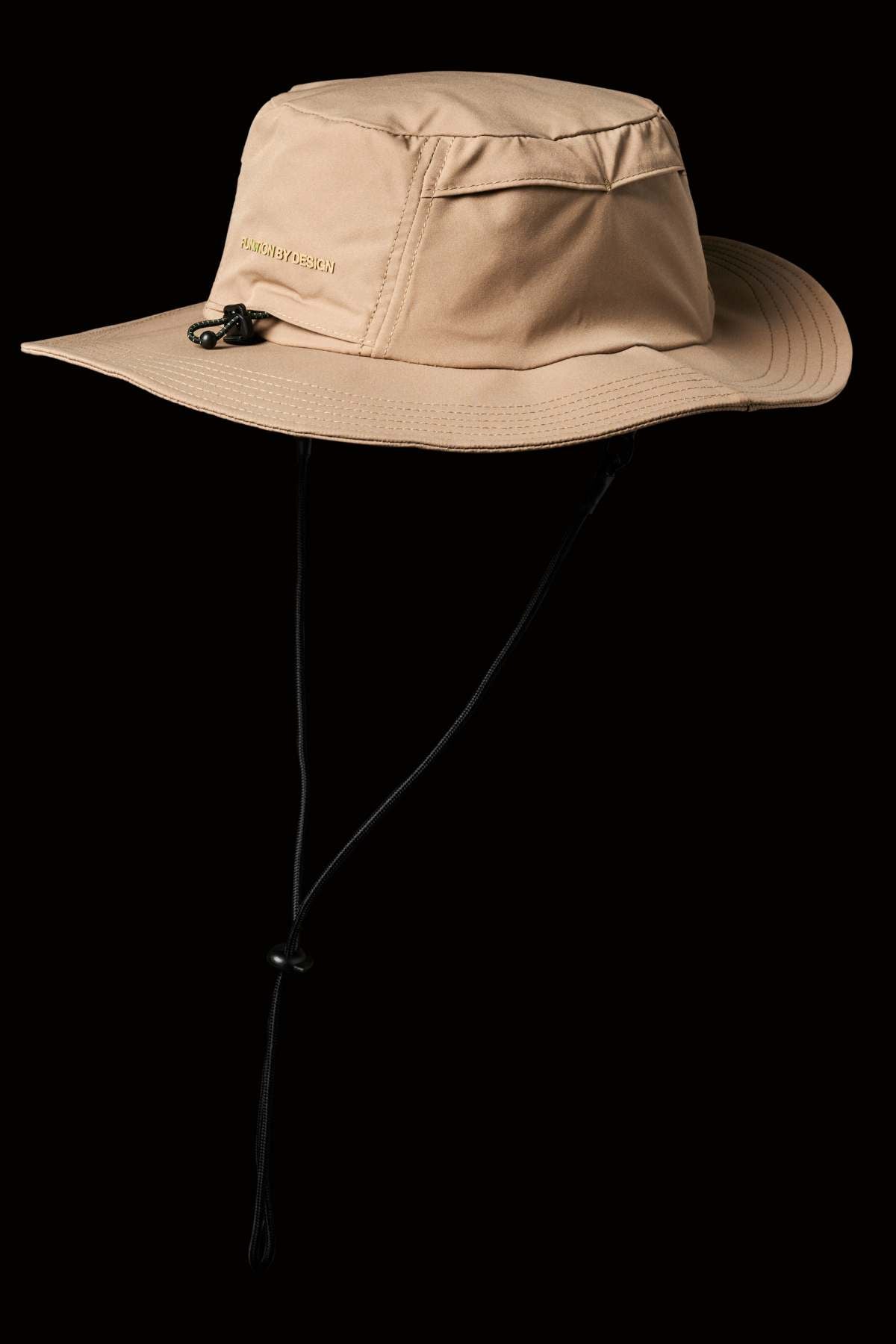 The FXD CP-14 Boonie Hat, in beige with a wide brim, chin strap, and side ventilation holes for sun protection, stands out against a black background.
