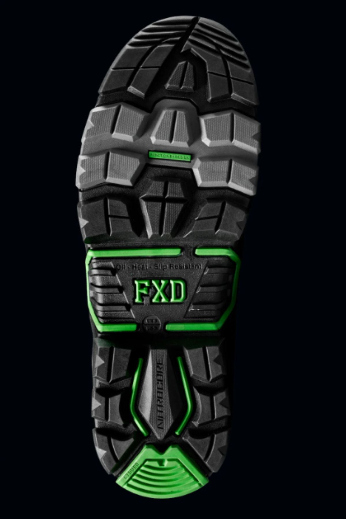 Close-up of the FXD DURA X-3 Slip On Work Boots' black and gray sole with green accents, deep treads, and "FXD" in the center, showcased against a dark background.